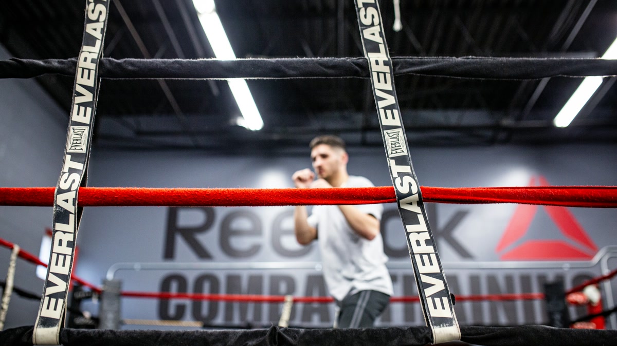 Beginner completing a controlled no-equipment shadowboxing workout in a clear room