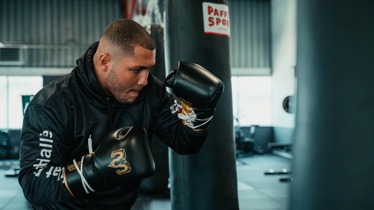 Beginner boxer checking a round timer before shadowboxing